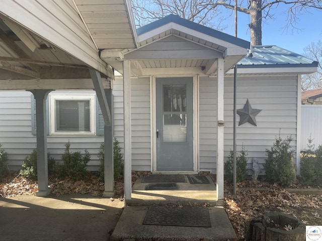 view of exterior entry featuring metal roof