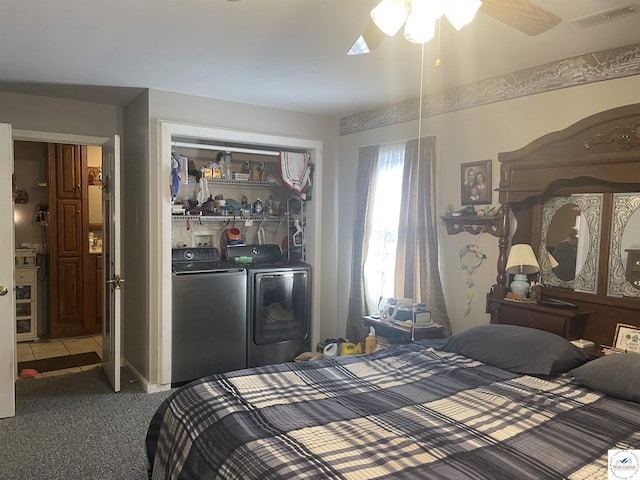 carpeted bedroom featuring a closet, visible vents, tile patterned flooring, and separate washer and dryer