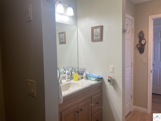 bathroom featuring vanity, baseboards, and wood finished floors