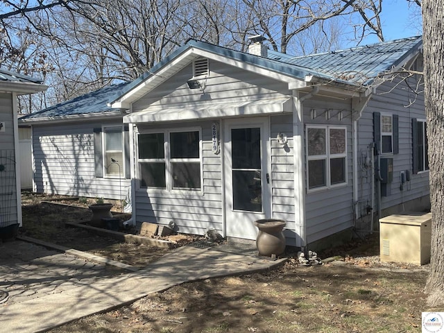 view of front of home featuring a chimney and metal roof