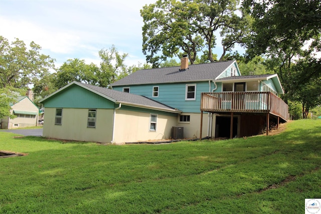 rear view of property featuring central air condition unit, roof with shingles, a lawn, a wooden deck, and a chimney