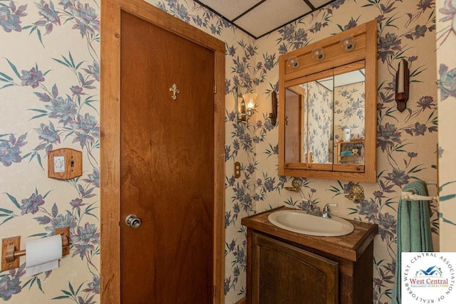 bathroom featuring vanity and wallpapered walls