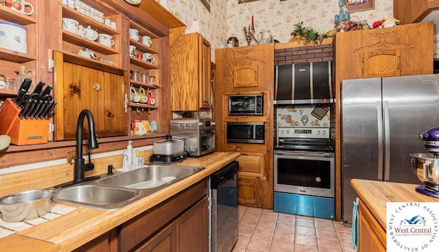 kitchen with open shelves, wallpapered walls, stainless steel appliances, and a sink