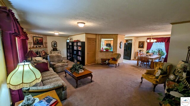 carpeted living area with a textured ceiling, a chandelier, and crown molding