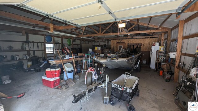 garage featuring a garage door opener and freestanding refrigerator