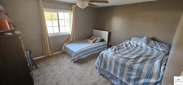 carpeted bedroom with ceiling fan and baseboards