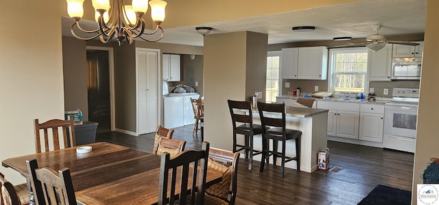 dining room featuring a textured ceiling, ceiling fan with notable chandelier, dark wood-type flooring, and independent washer and dryer