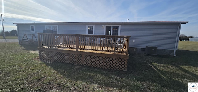 back of property with a deck, central AC, and a yard