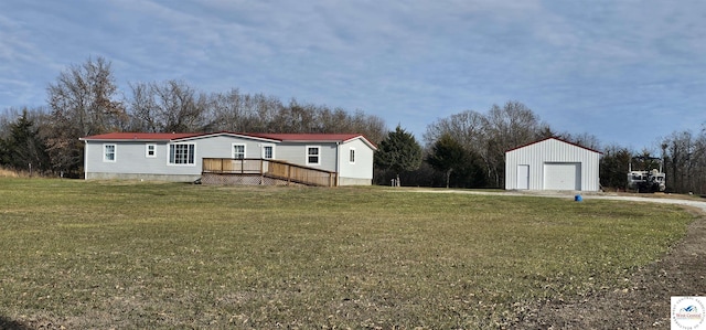 view of yard with a detached garage, a deck, and an outbuilding