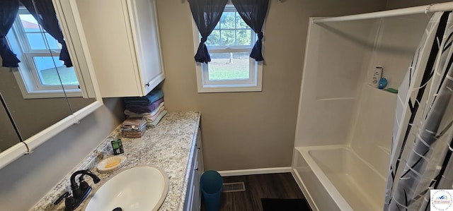 full bath with shower / tub combo, wood finished floors, vanity, visible vents, and baseboards