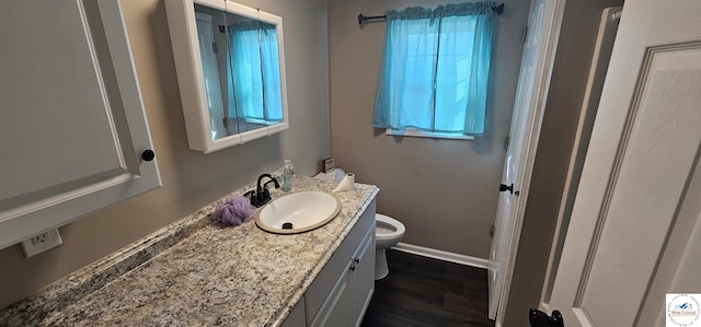 bathroom with toilet, baseboards, wood finished floors, and vanity