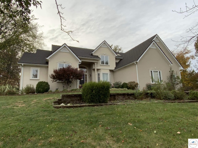 ranch-style home with a front lawn and stucco siding