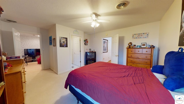 bedroom with visible vents, light carpet, and a textured ceiling