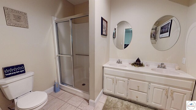 bathroom featuring a sink, double vanity, a shower stall, and toilet