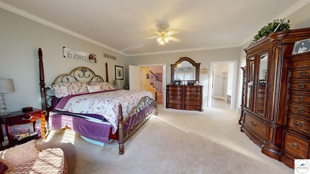 bedroom with crown molding, light colored carpet, visible vents, ensuite bathroom, and a ceiling fan