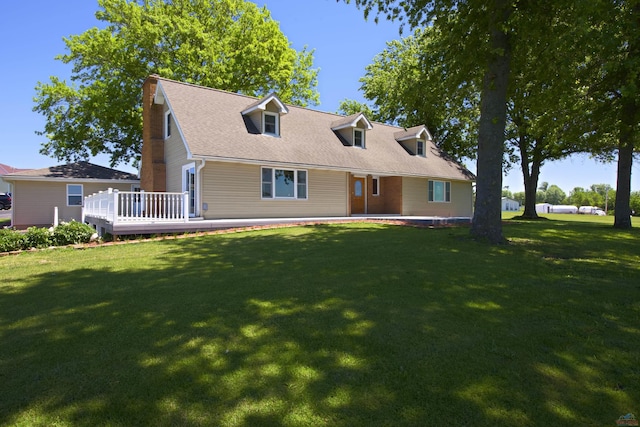 cape cod house featuring a deck and a front lawn