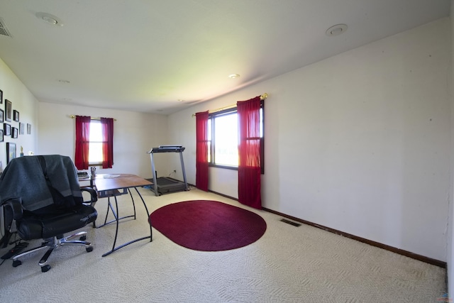 office space with baseboards, visible vents, and light colored carpet