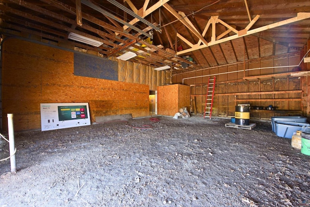 miscellaneous room with a garage and lofted ceiling