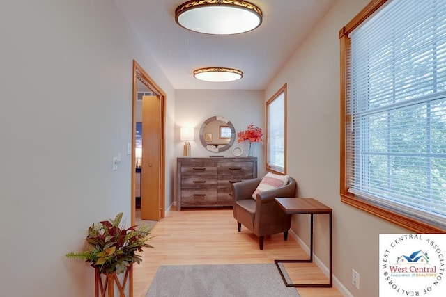 living area featuring light wood-style flooring and baseboards