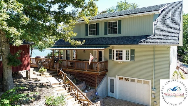 view of front of home with a garage and roof with shingles