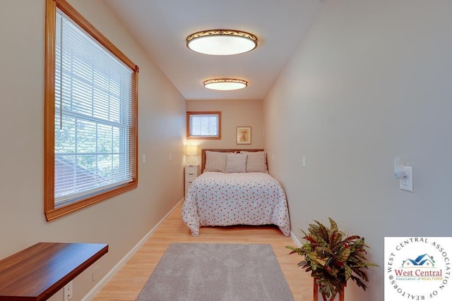 bedroom with light wood-type flooring and baseboards