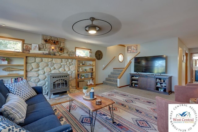 living area with light carpet, baseboards, and stairway