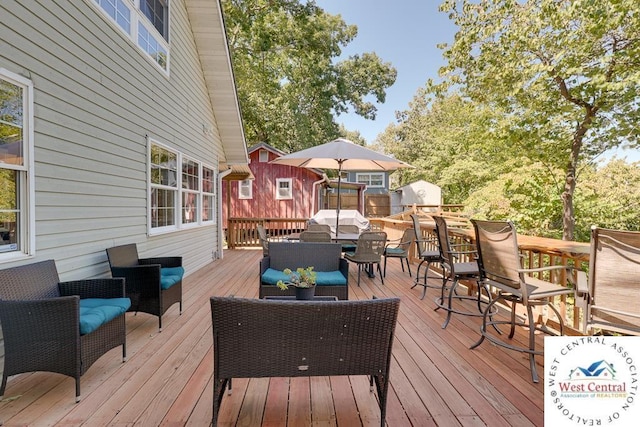 wooden deck featuring an outdoor living space and an outbuilding