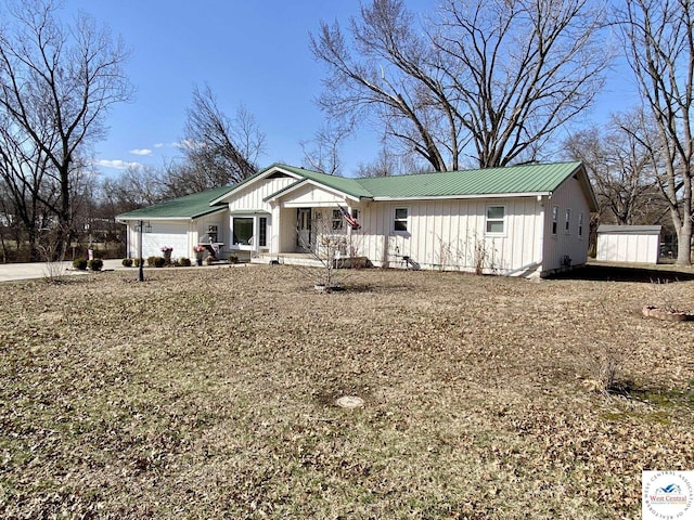 view of front facade with a garage, metal roof, and board and batten siding