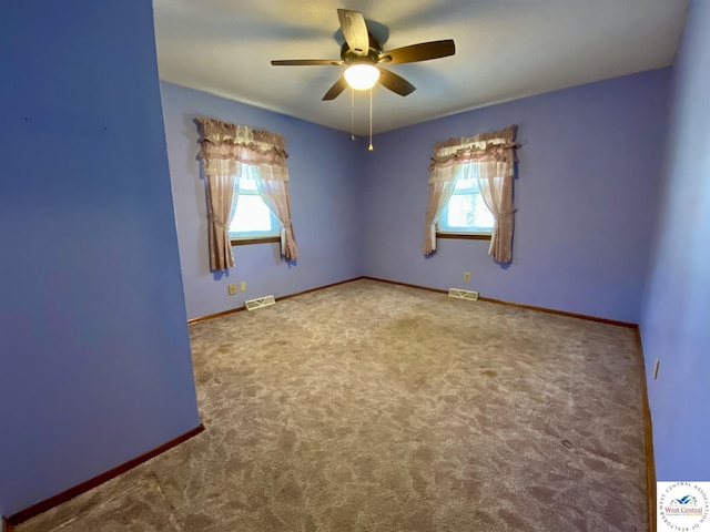 spare room featuring a ceiling fan, carpet, visible vents, and baseboards