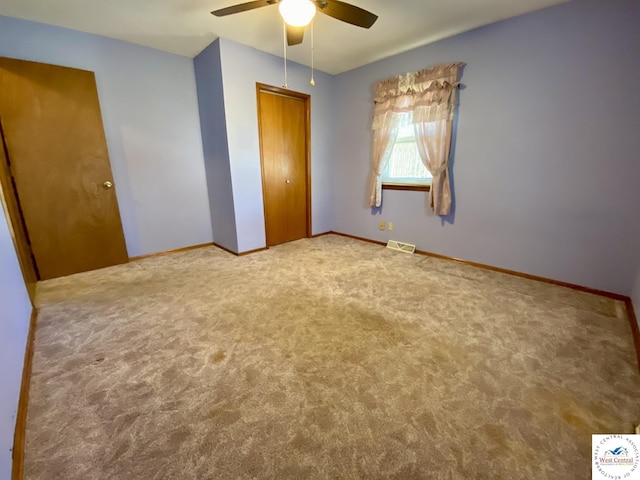 unfurnished bedroom featuring visible vents, baseboards, ceiling fan, carpet, and a closet