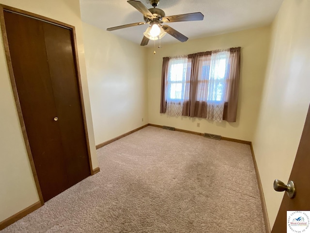 unfurnished bedroom featuring light carpet, a closet, and baseboards