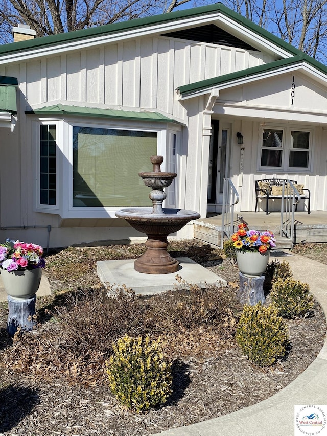 property entrance with a porch, board and batten siding, and a chimney