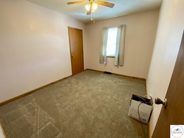 spare room with carpet floors, baseboards, and a ceiling fan