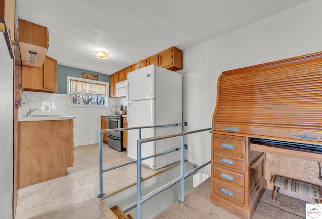 kitchen featuring light tile patterned floors, white appliances, tile walls, light countertops, and brown cabinets