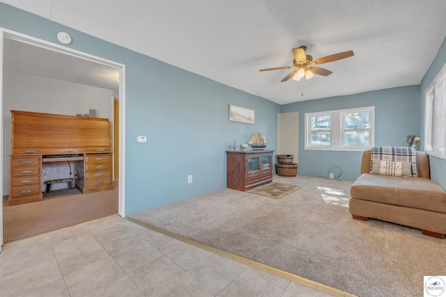 living area featuring carpet floors, ceiling fan, and tile patterned floors