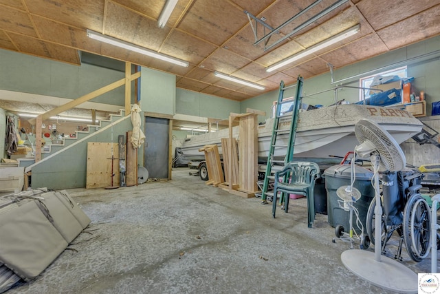 miscellaneous room featuring concrete flooring and stairs