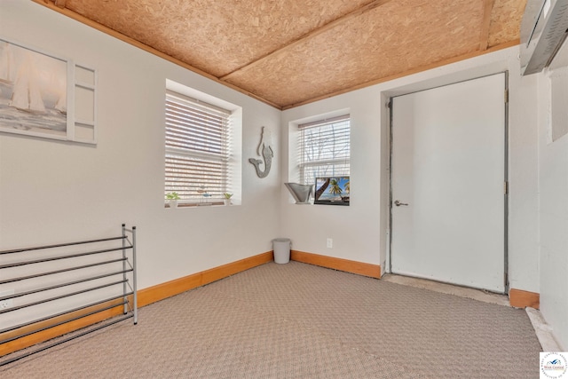 carpeted empty room with baseboards