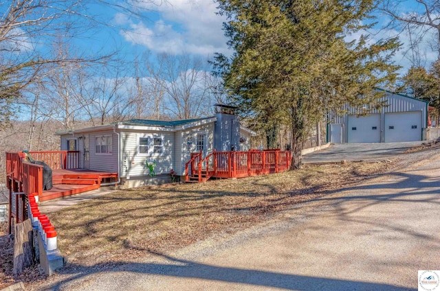 ranch-style home featuring a deck and an outbuilding