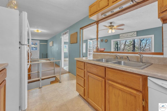 kitchen with white appliances, light tile patterned floors, ceiling fan, light countertops, and a sink