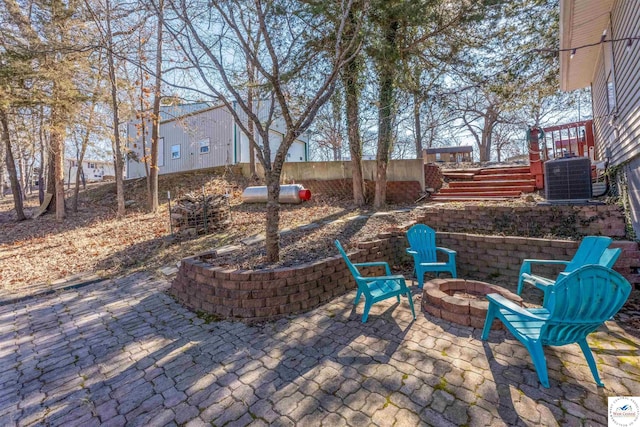 view of patio / terrace featuring cooling unit, an outdoor fire pit, and stairway