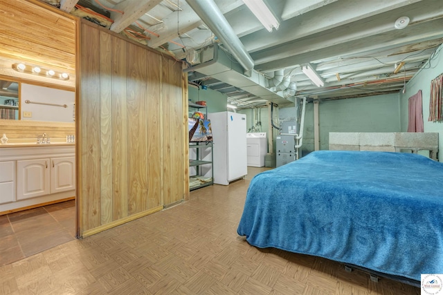 bedroom featuring ensuite bathroom, washer / clothes dryer, a sink, and heating unit