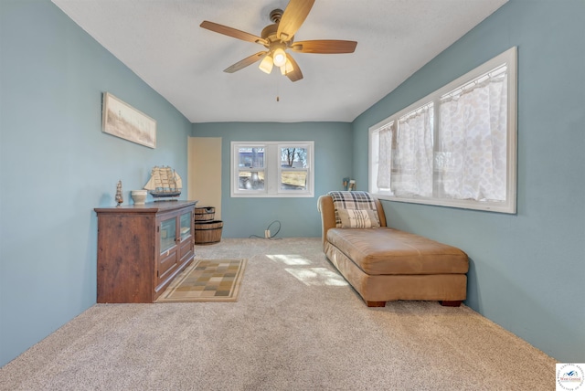 living area featuring carpet flooring and ceiling fan