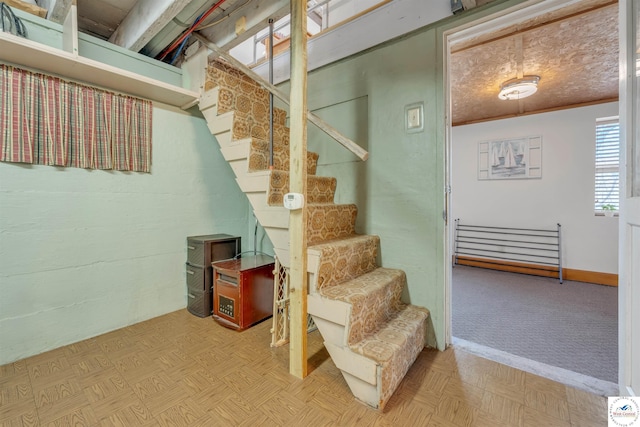 basement featuring ornamental molding, stairway, and a textured ceiling