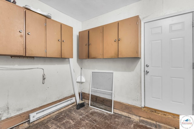 clothes washing area featuring dark floors and baseboard heating