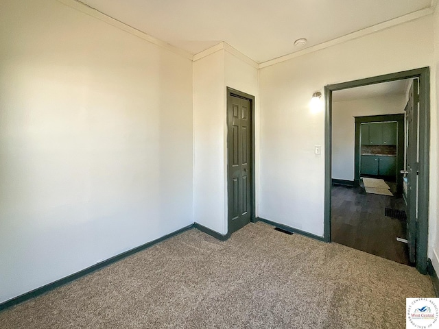 unfurnished bedroom featuring baseboards, carpet floors, visible vents, and crown molding