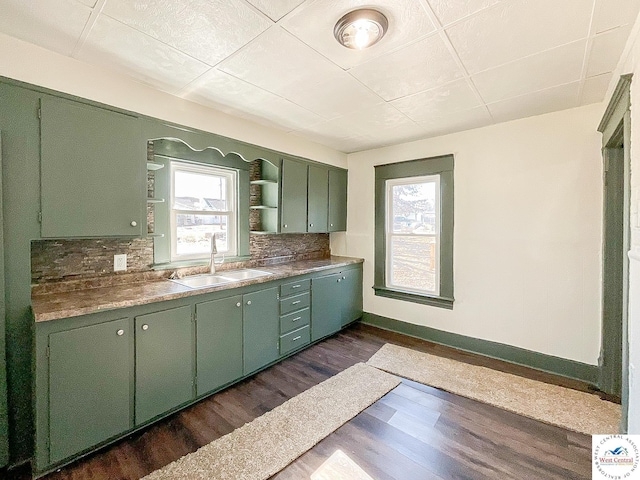 kitchen featuring a healthy amount of sunlight, green cabinets, and a sink