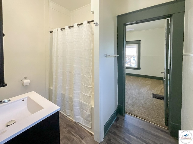 bathroom with vanity, wood finished floors, visible vents, and baseboards