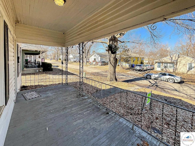 wooden terrace featuring a porch and a residential view