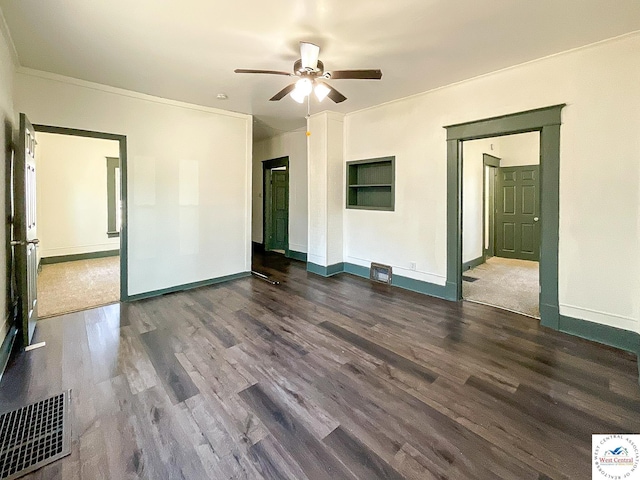 unfurnished room with crown molding, visible vents, ceiling fan, wood finished floors, and baseboards