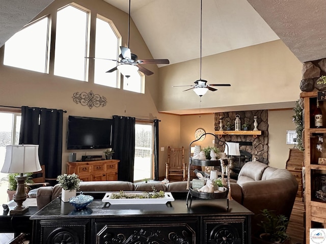 living room featuring a healthy amount of sunlight, ceiling fan, a fireplace, and vaulted ceiling